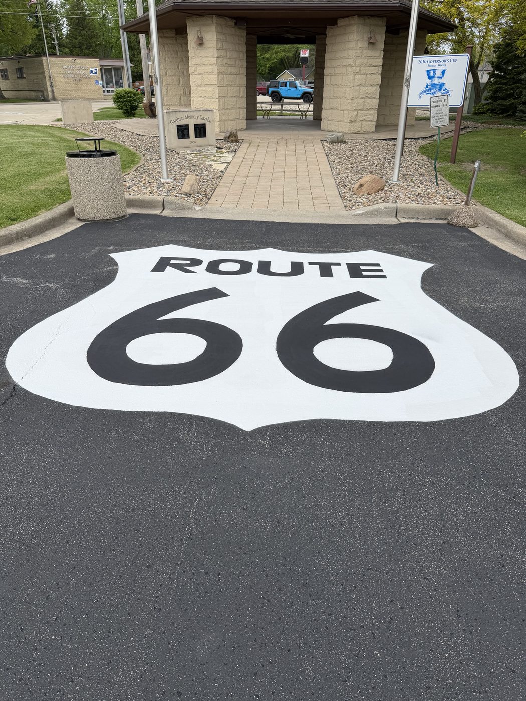 Route 66 shield painted on pavement at Gardner Memory Gazebo